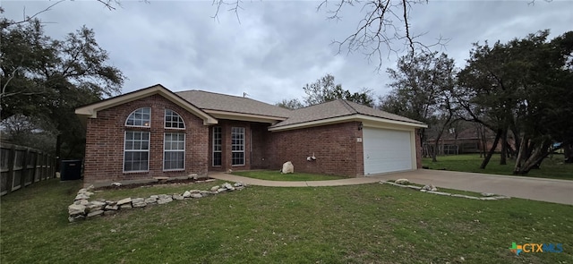 view of front facade featuring a front yard, brick siding, and driveway