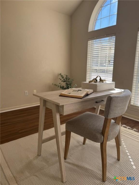 dining space with lofted ceiling and wood-type flooring