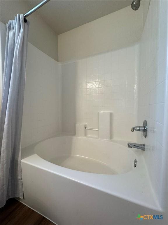 bathroom with shower / tub combo with curtain and hardwood / wood-style floors