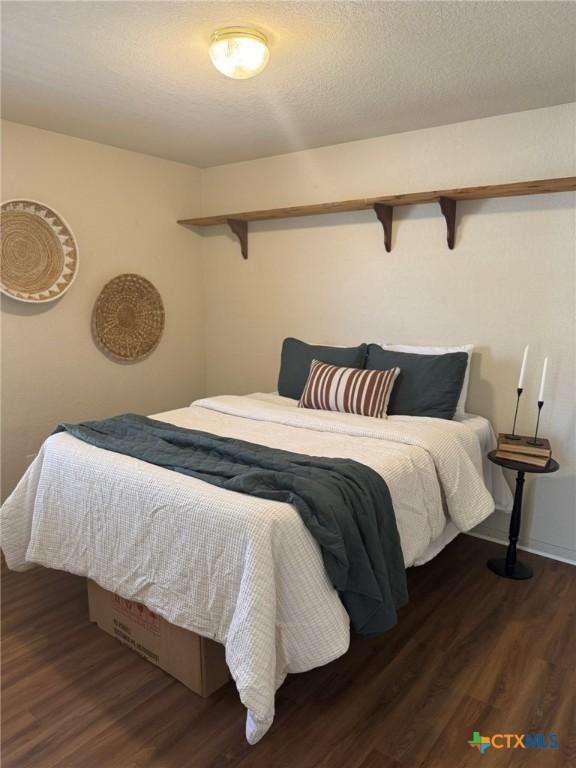 bedroom with dark hardwood / wood-style flooring