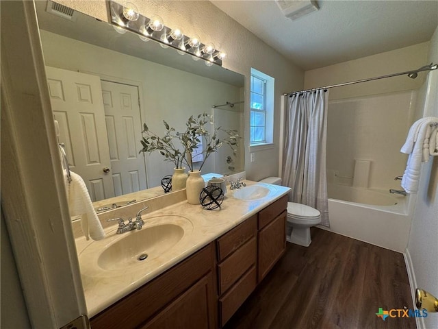 full bathroom with vanity, hardwood / wood-style flooring, toilet, and shower / bath combo