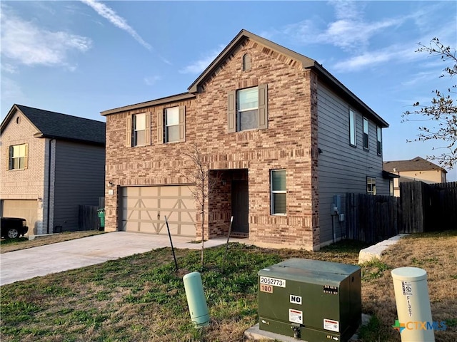 traditional home with driveway, fence, and brick siding