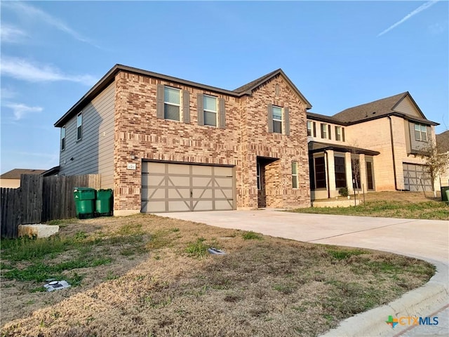 traditional home featuring driveway, an attached garage, fence, and brick siding