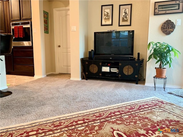 living room featuring baseboards and light colored carpet