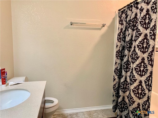 full bathroom with toilet, baseboards, and vanity