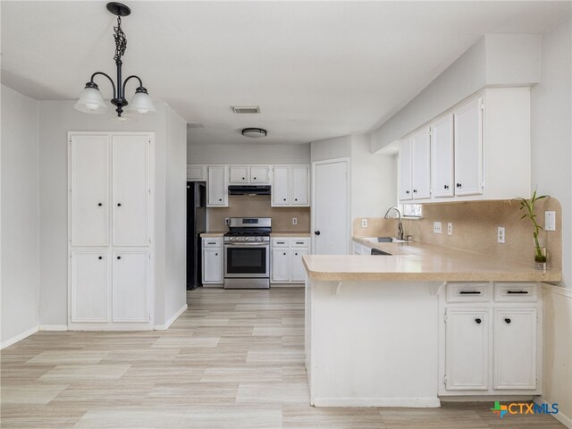 1304 Wroxton Way, Round Rock, TX 78664 - kitchen featuring stainless steel range with gas stovetop, under cabinet range hood, a peninsula, light countertops, and white cabinetry