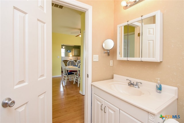 bathroom with hardwood / wood-style floors, vanity, and ceiling fan