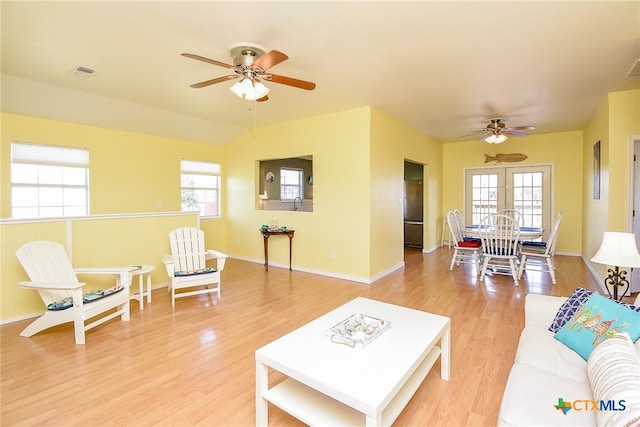 living room featuring hardwood / wood-style floors, plenty of natural light, ceiling fan, and french doors