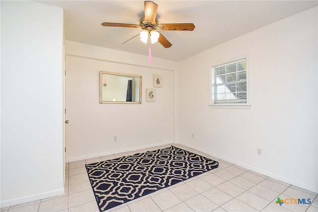 tiled spare room featuring ceiling fan