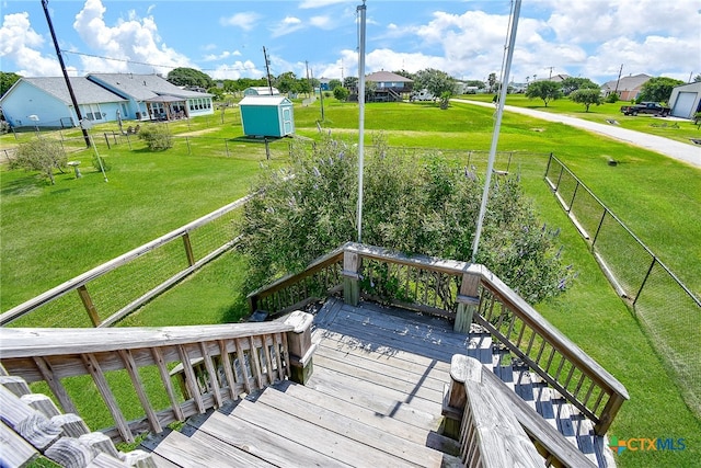 deck with a lawn and a storage unit