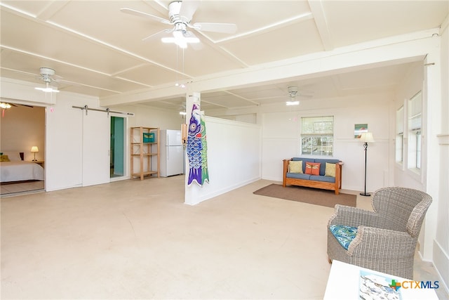 interior space with ceiling fan, a barn door, and concrete flooring