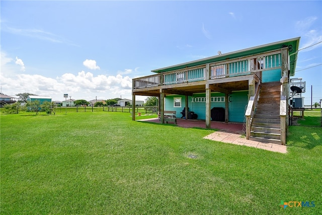 back of property featuring a yard, a patio, and a wooden deck