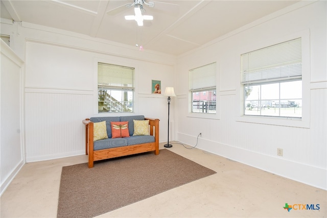 living area featuring concrete flooring and ceiling fan