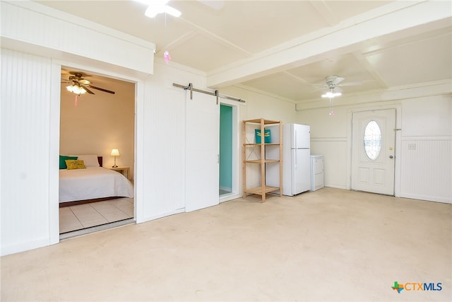 foyer entrance featuring concrete flooring, ceiling fan, beam ceiling, a barn door, and separate washer and dryer