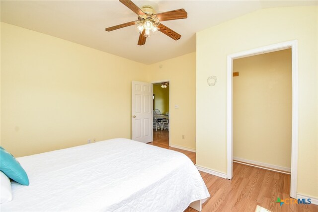 bedroom with vaulted ceiling, light hardwood / wood-style flooring, and ceiling fan