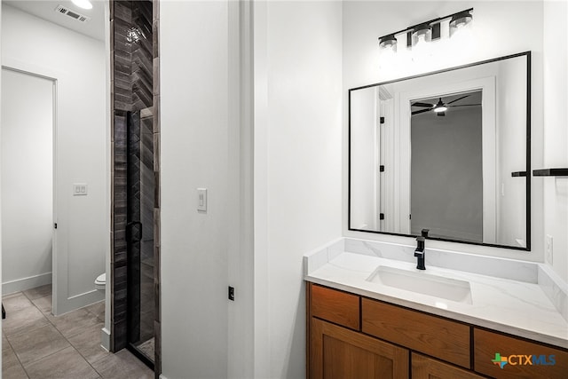 bathroom with toilet, vanity, tile patterned flooring, and ceiling fan