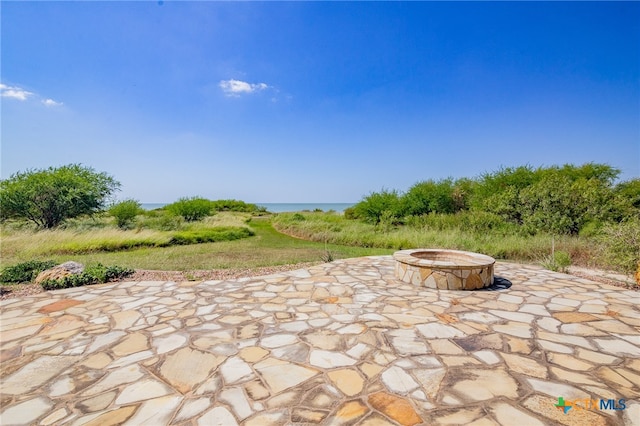 view of patio / terrace featuring a water view and an outdoor fire pit