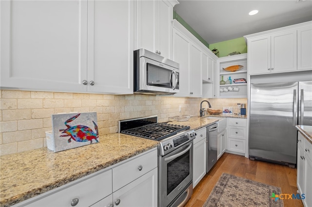 kitchen featuring white cabinetry, stainless steel appliances, dark hardwood / wood-style floors, and light stone countertops