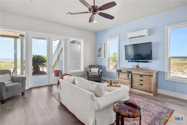 living room featuring dark wood-type flooring, a wall mounted AC, plenty of natural light, and ceiling fan