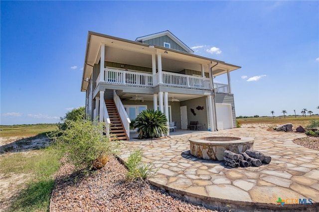 rear view of property featuring a patio and a fire pit