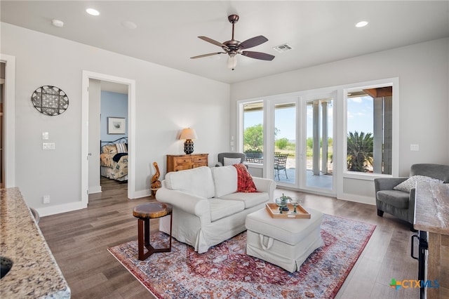 living room with dark wood-type flooring and ceiling fan