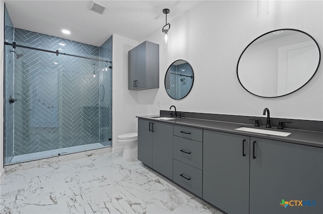 bathroom featuring a shower with door, vanity, and toilet