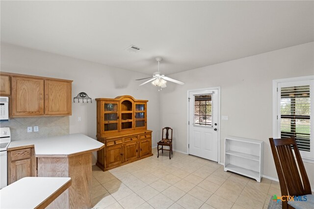 kitchen with white appliances, ceiling fan, tasteful backsplash, light tile patterned flooring, and kitchen peninsula