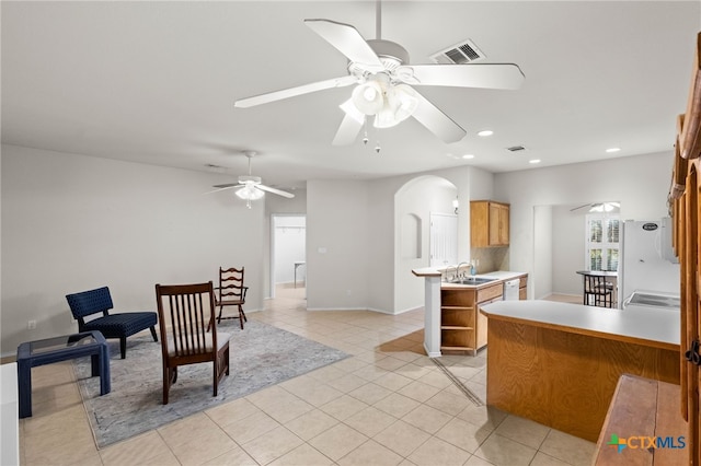 kitchen featuring ceiling fan, kitchen peninsula, sink, and light tile patterned floors