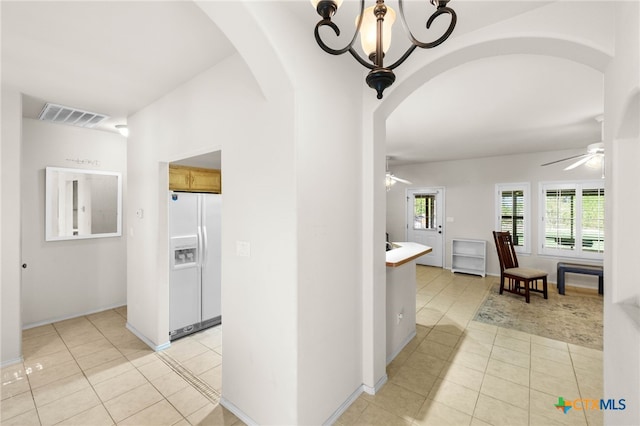 hallway featuring light tile patterned floors and a notable chandelier