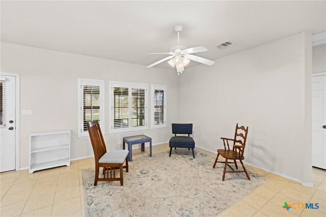 living area featuring ceiling fan and light tile patterned floors