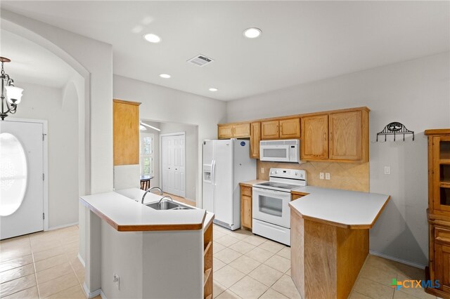 kitchen featuring sink, a notable chandelier, kitchen peninsula, white appliances, and washer / dryer