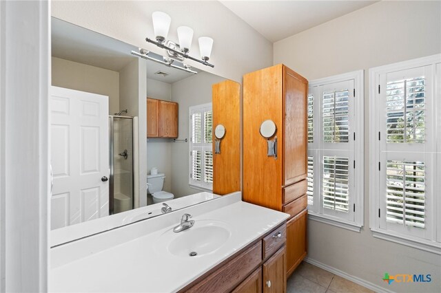 bathroom featuring toilet, vanity, tile patterned floors, and walk in shower