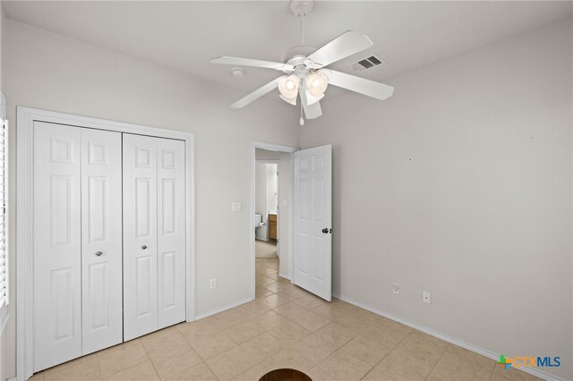 unfurnished bedroom with light tile patterned floors, a closet, and ceiling fan