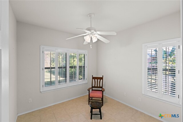 sitting room with ceiling fan and light tile patterned flooring