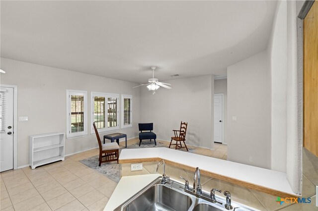 kitchen featuring ceiling fan, light tile patterned flooring, kitchen peninsula, and sink