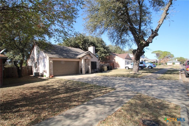 single story home with central air condition unit and a garage