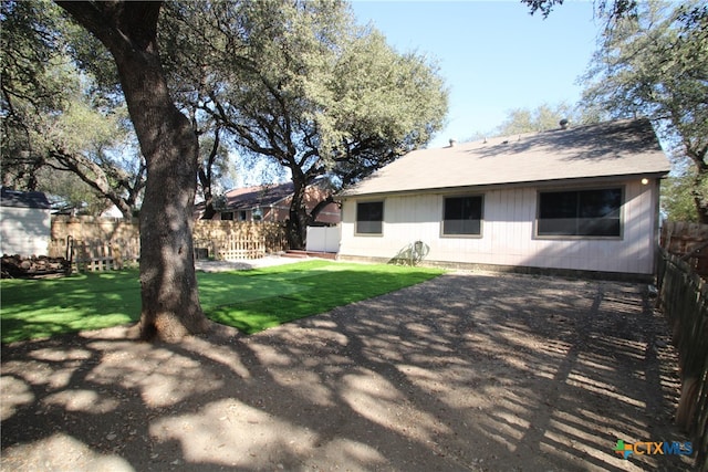 rear view of property featuring a lawn