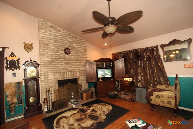 living room featuring a fireplace, hardwood / wood-style flooring, ceiling fan, and vaulted ceiling