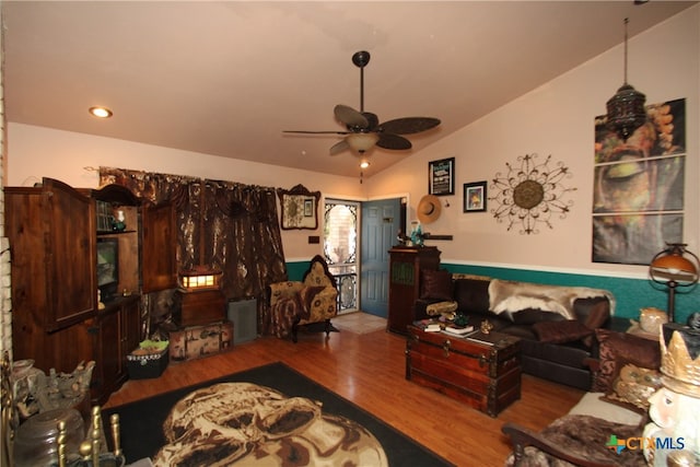 living room featuring wood-type flooring, vaulted ceiling, and ceiling fan