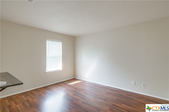 unfurnished room with wood-type flooring