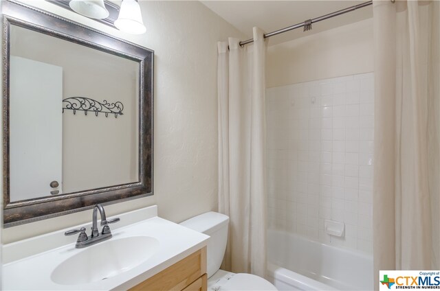 full bathroom with shower / tub combo with curtain, vanity, and toilet