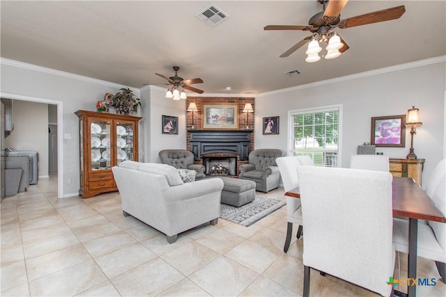 living room featuring washer / clothes dryer, crown molding, and a fireplace