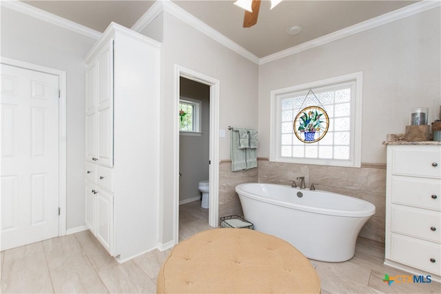 bathroom with a wealth of natural light, ceiling fan, a bath, and tile walls