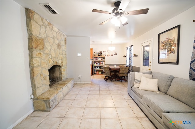 living room with light tile patterned floors, ceiling fan, and a fireplace