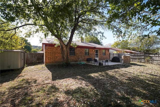 back of house featuring a storage unit and a patio