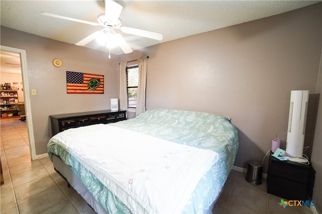 tiled bedroom with a textured ceiling and ceiling fan