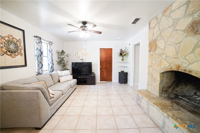 living room with light tile patterned floors, ceiling fan, and a fireplace