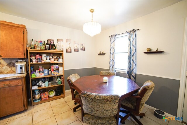 tiled dining space featuring a notable chandelier