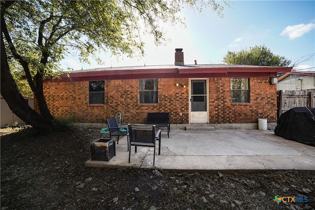 rear view of house with a fire pit and a patio area