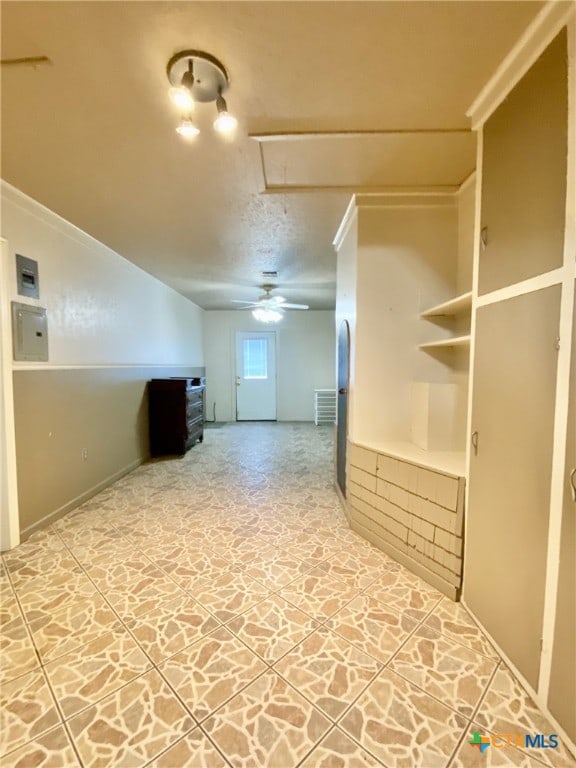 interior space featuring stone finish flooring, attic access, and a ceiling fan